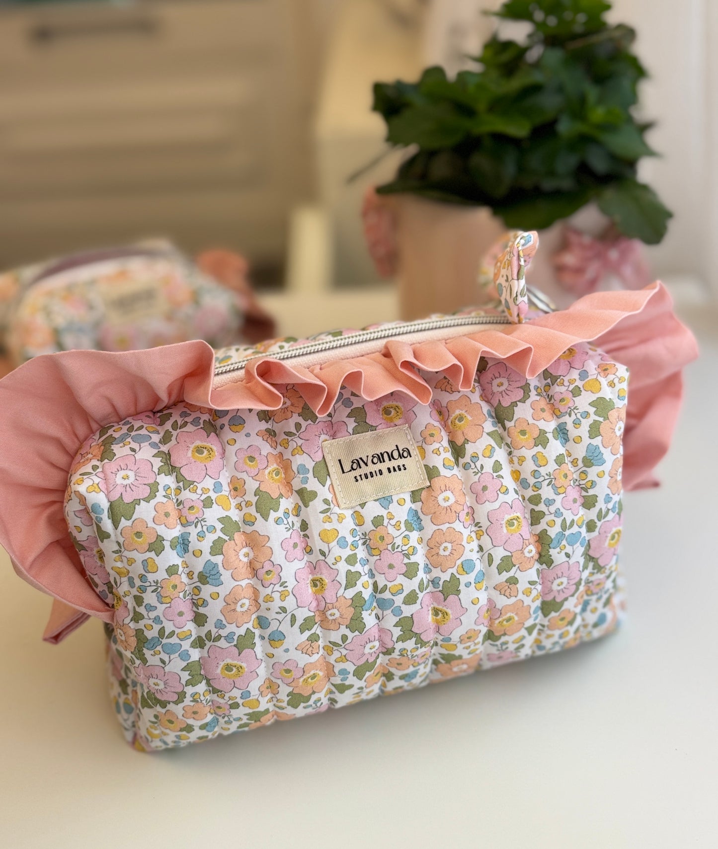 Bolsa de cosméticos Fresia com estampado de flores e folhos.