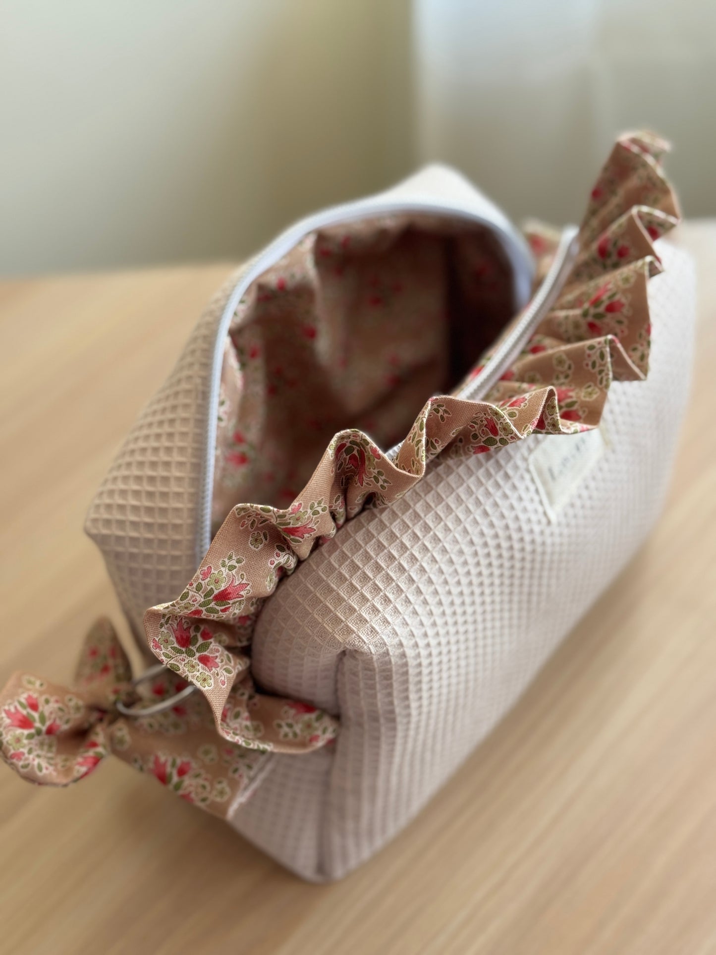 a.Cosmetic bag fresia beige canela flowers.