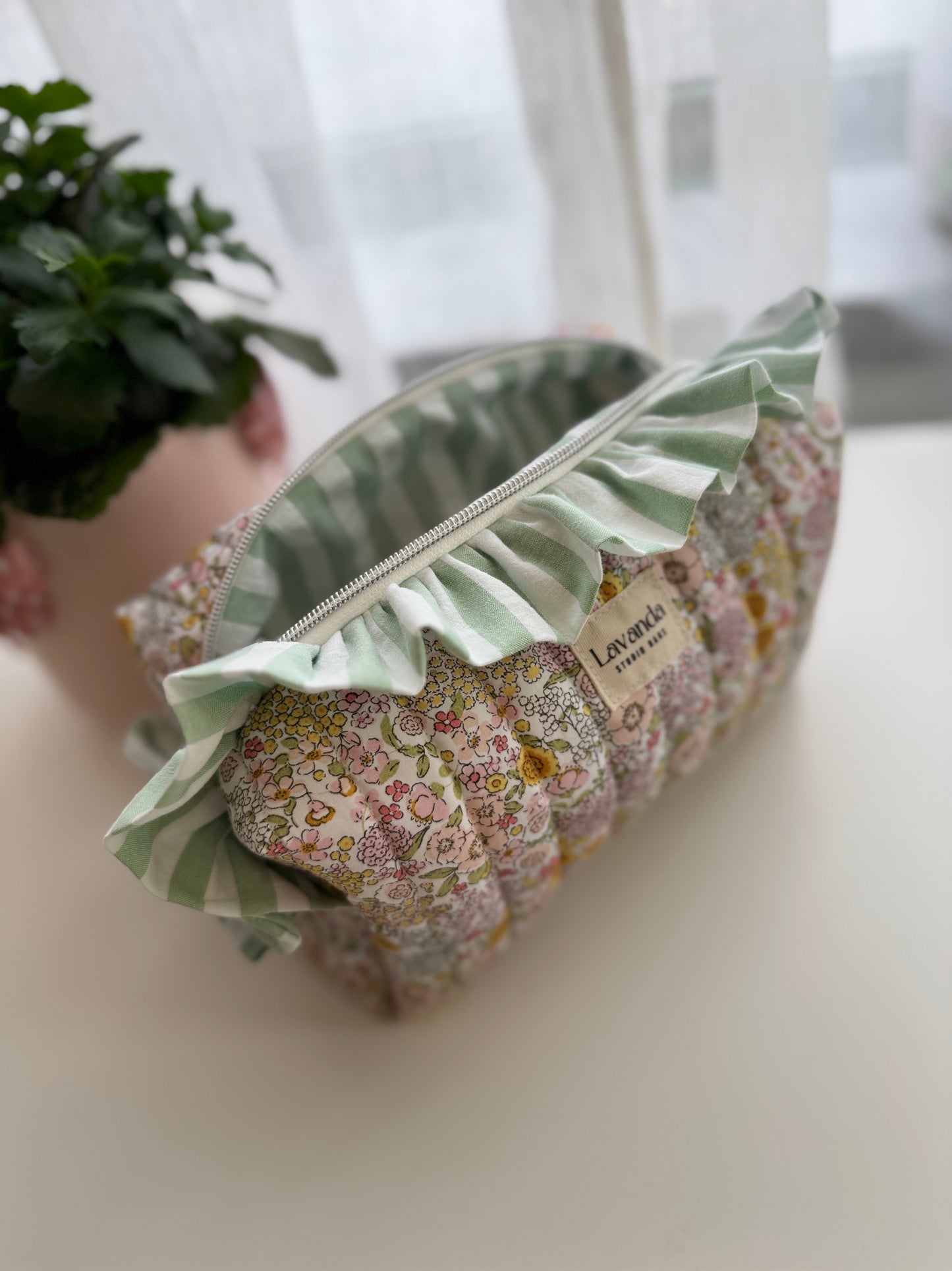 Bolsa de cosméticos Fresia com estampado de flores e folhos.