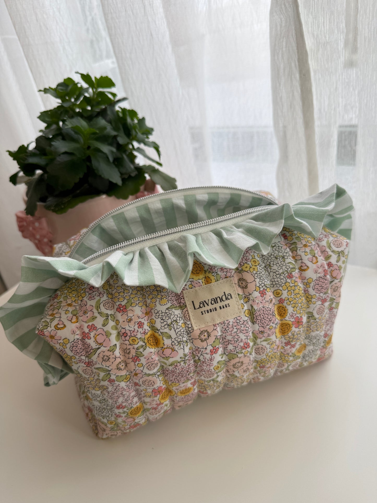 Bolsa de cosméticos Fresia com estampado de flores e folhos.