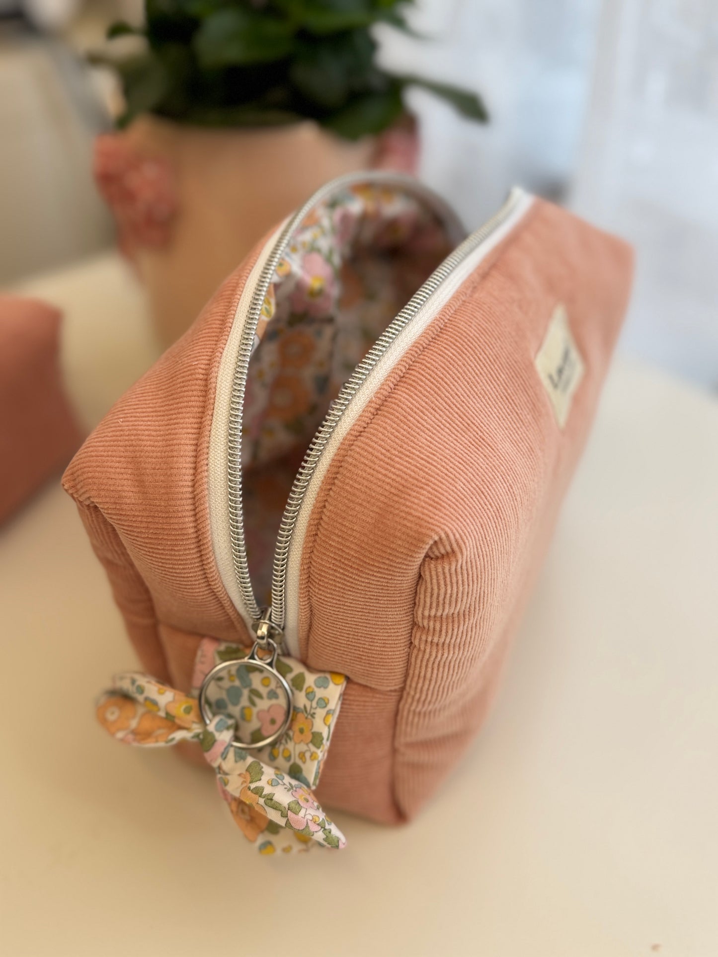 Nécessaire de cosméticos Fresia com flores simples no interior.
