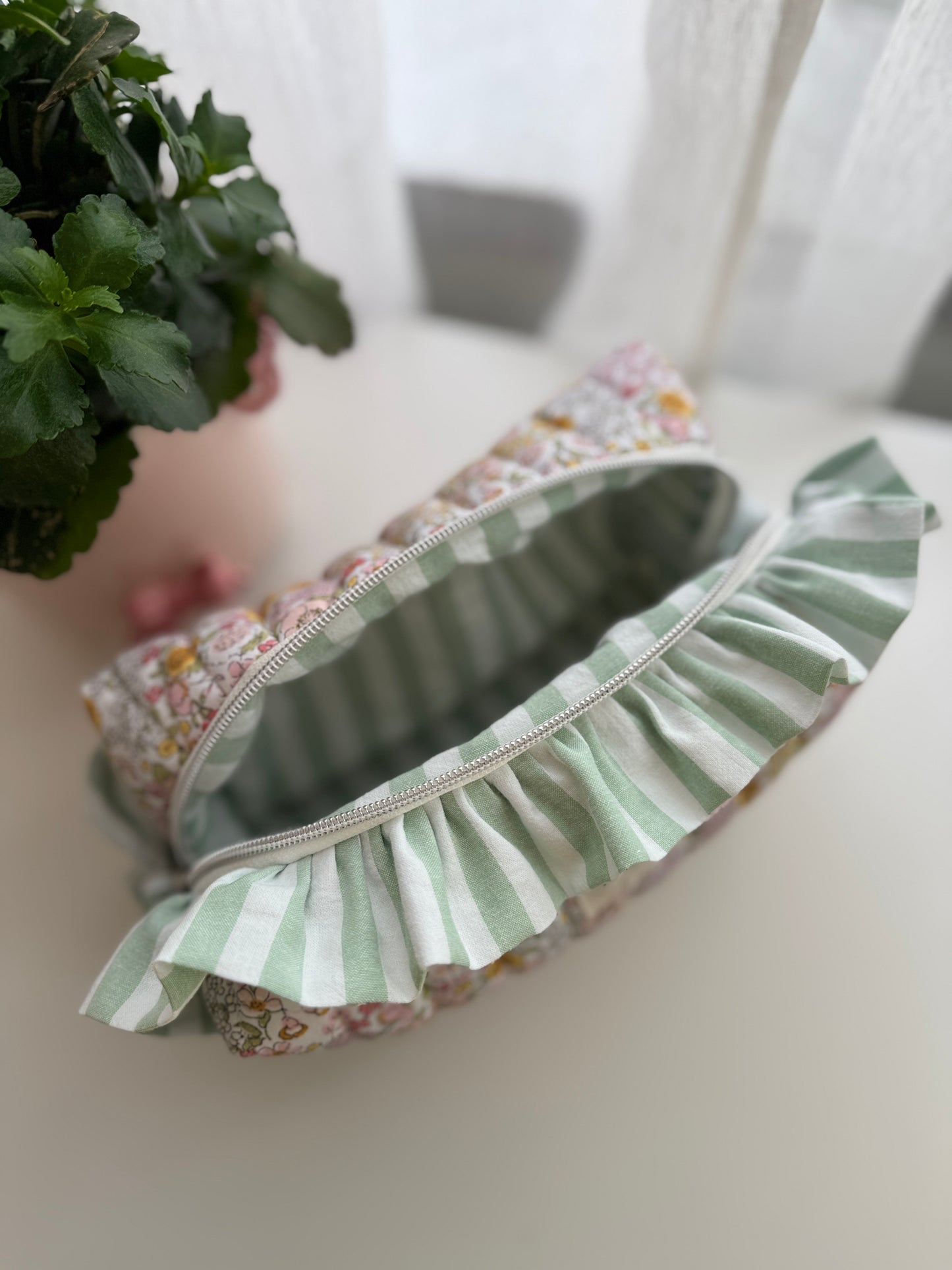 Bolsa de cosméticos Fresia com estampado de flores e folhos.