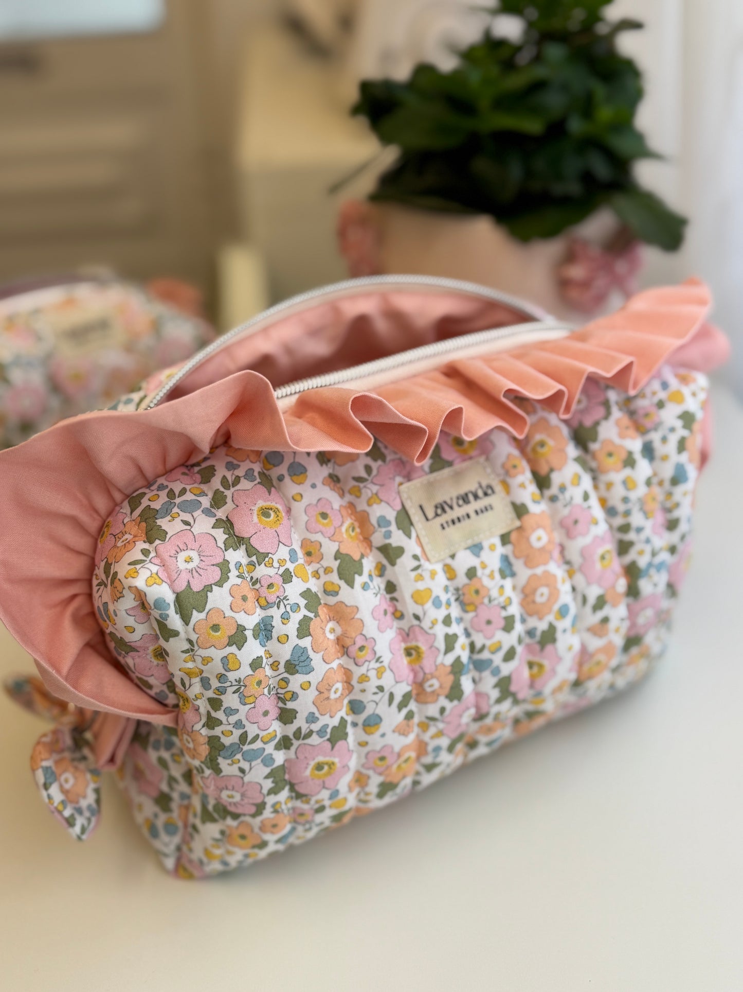 Bolsa de cosméticos Fresia com estampado de flores e folhos.