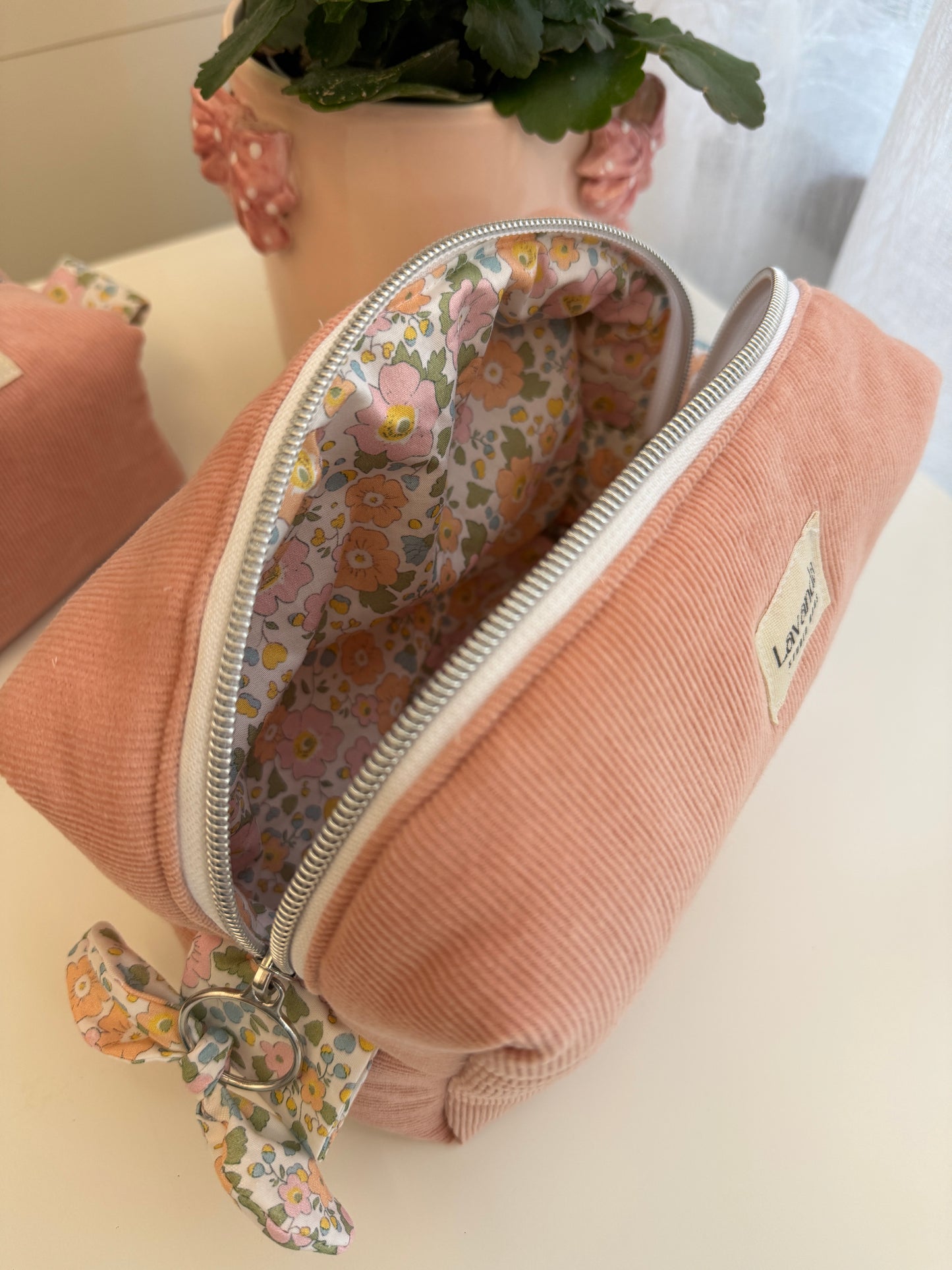 Nécessaire de cosméticos Fresia com flores simples no interior.