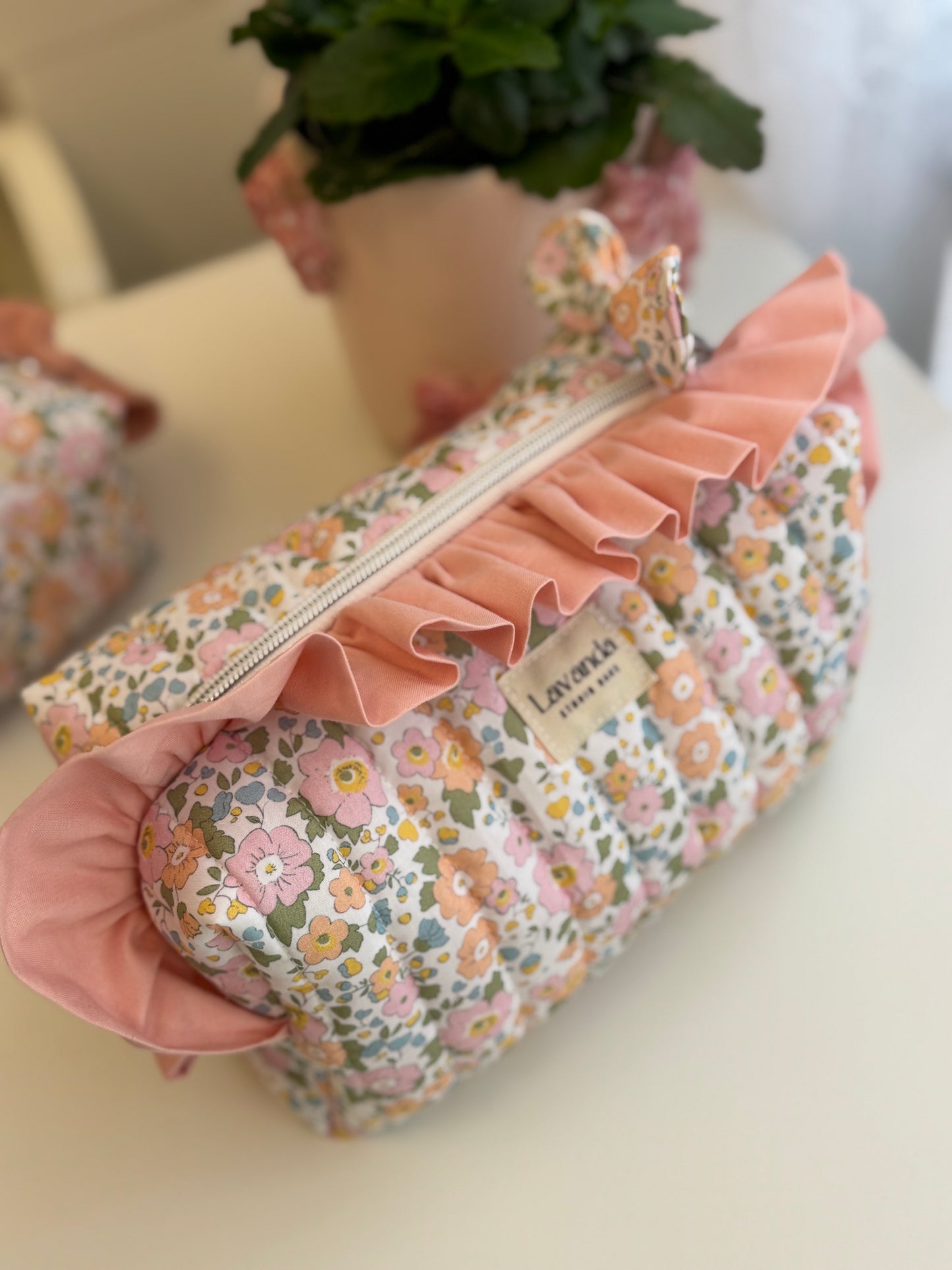 Bolsa de cosméticos Fresia com estampado de flores e folhos.